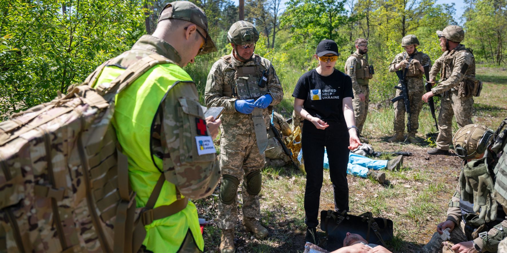 Three people on the photo during the tac med school training in Ukraine. Two people wear military form and one instructor wears ICTM t-shirt