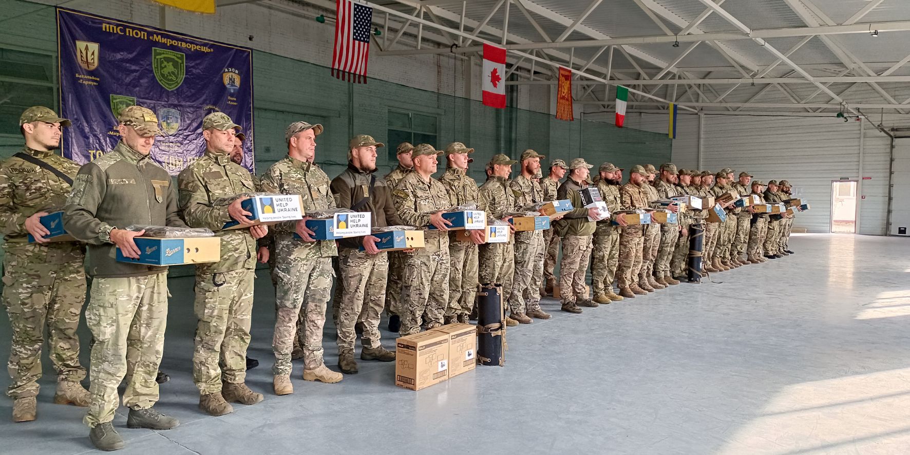 Ukrainian defenders holding the boxes with essential live-saving equipment provided by United Help Ukraine