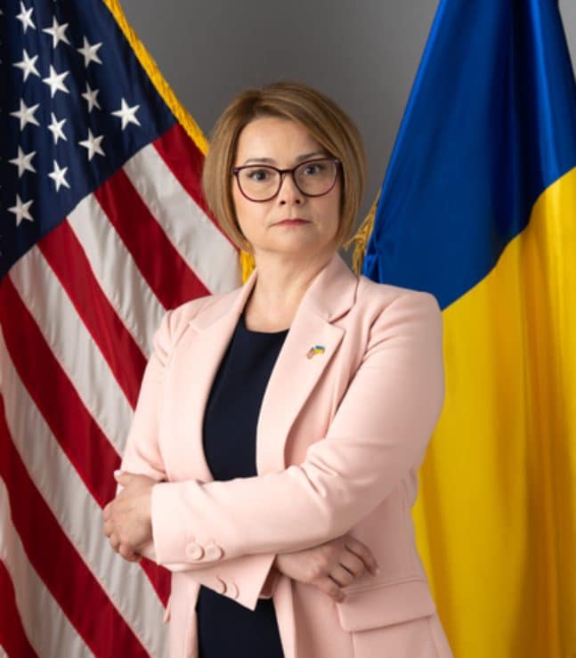 Maryna Baydyuk, the president of United Help Ukraine, and two flags behind: Ukrainian and American ones.